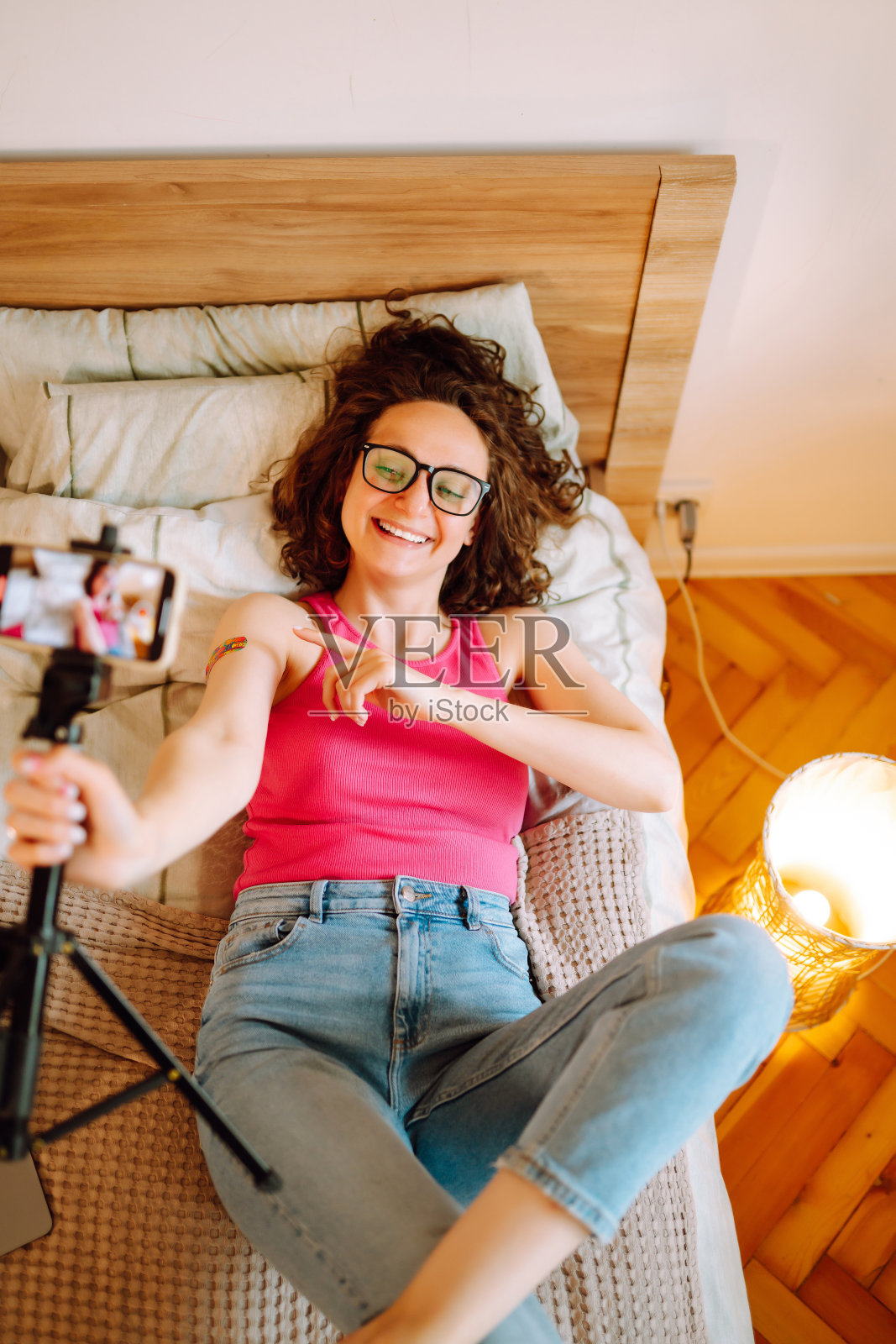 接种疫苗。年轻女性博主与粉丝交谈，直播并展示她手上的胶布，讲述covid-19疫苗。照片摄影图片