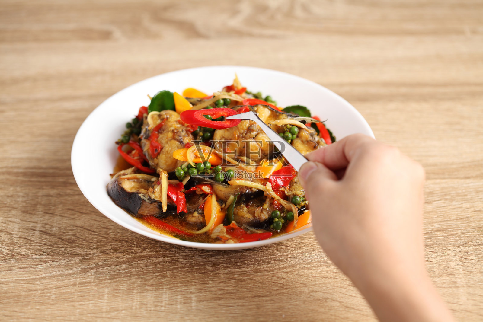 食物设计师用镊子在白色的盘子里装饰泰国菜照片摄影图片