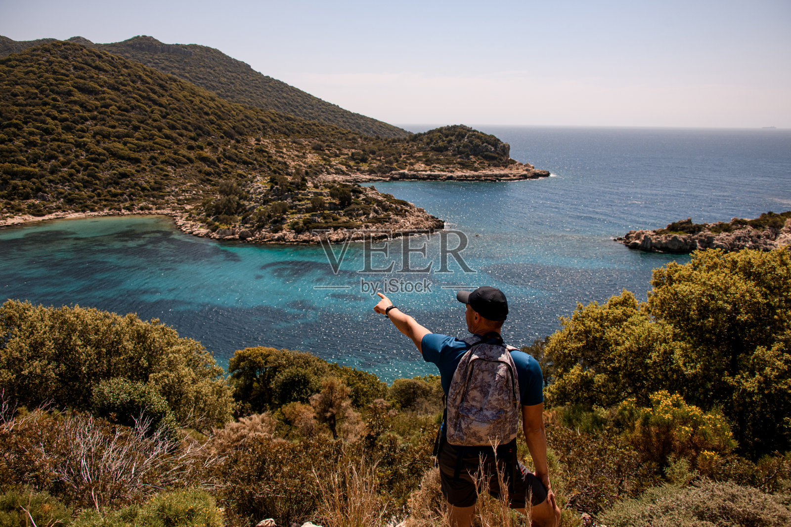 男游客用手指着美丽的海湾照片摄影图片