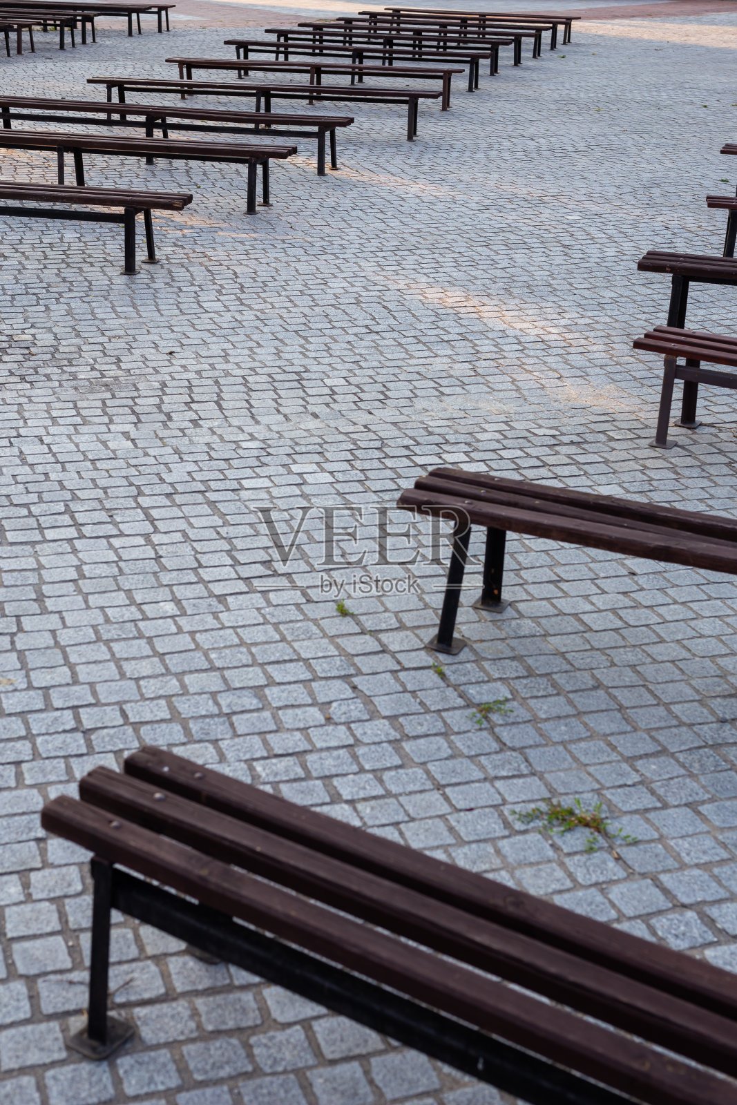 用花岗岩铺成的广场上有许多长凳。照片摄影图片