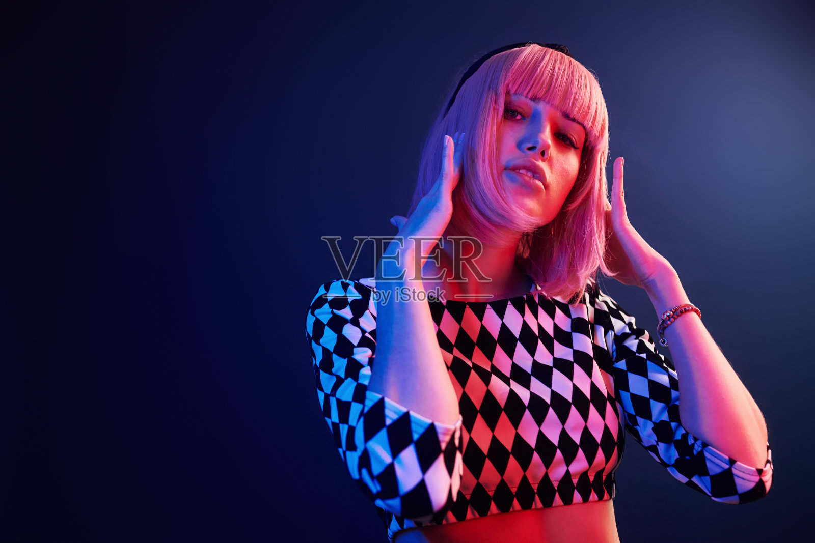 在工作室的年轻女孩的肖像与红色和蓝色霓虹灯金发照片摄影图片