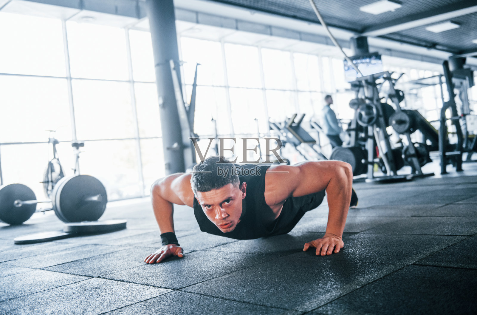 强壮的年轻人穿着运动服在健身房做俯卧撑照片摄影图片