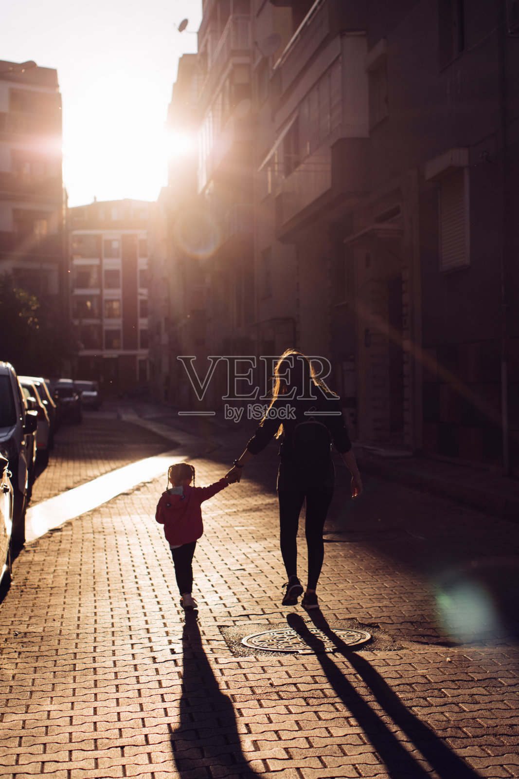 小女孩和妈妈走在街上照片摄影图片