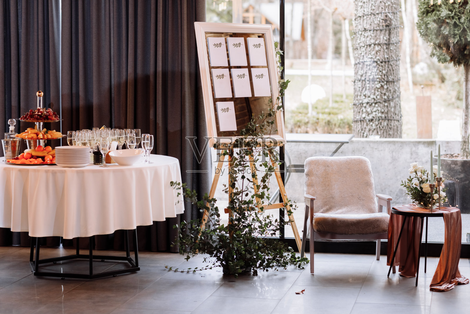 画架与木制时尚板名单座位计划婚宴。复古奢华的婚礼。为客人准备水果和香槟的桌子照片摄影图片