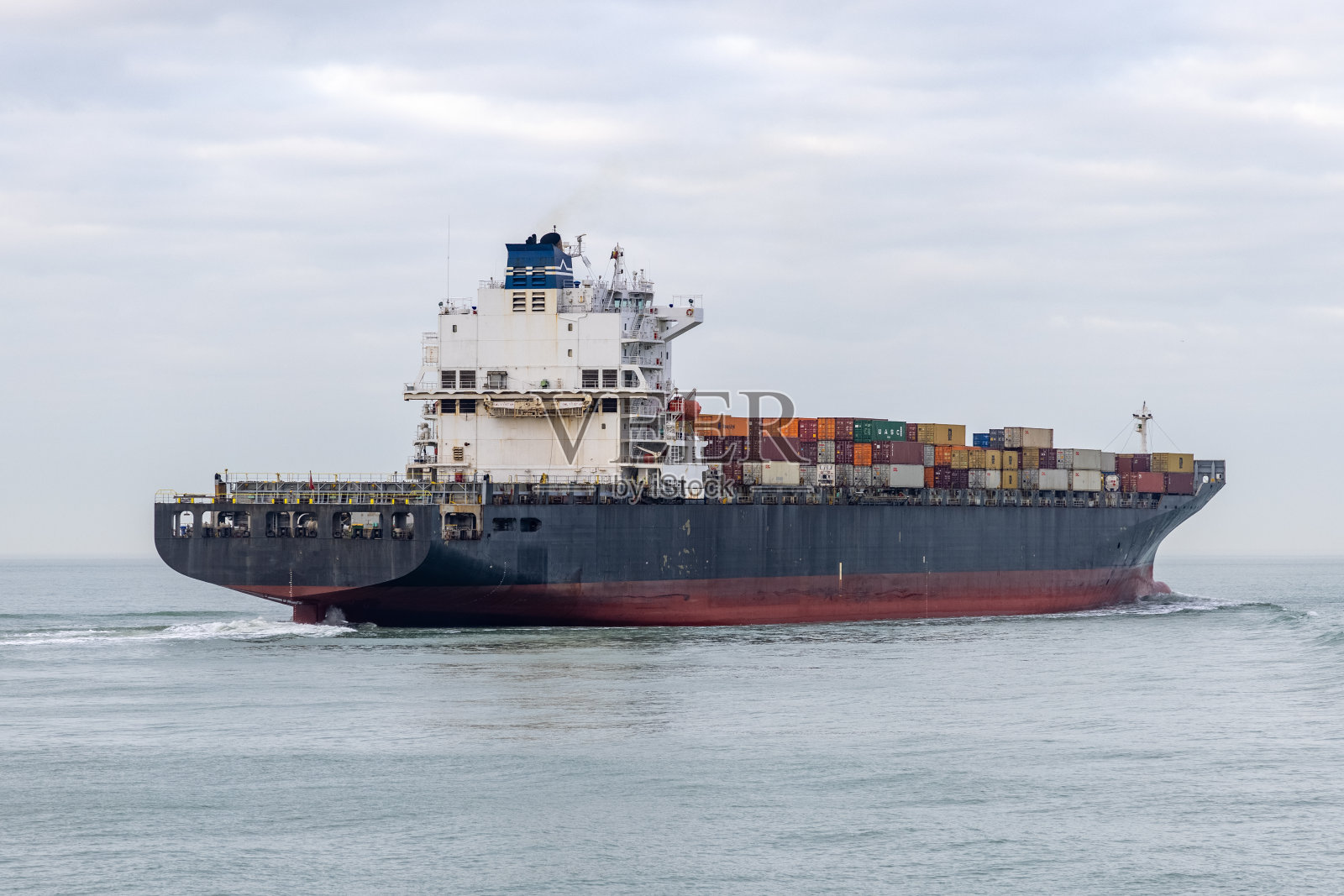 货船经过海滩照片摄影图片