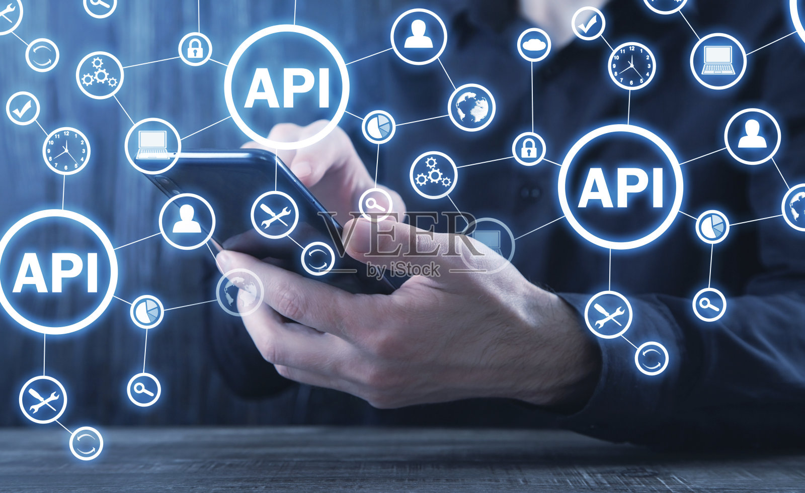 男人拿着智能手机。API。应用程序编程接口。软件开发。技术照片摄影图片