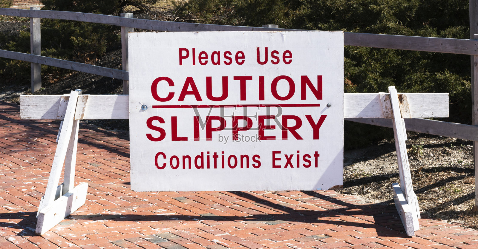 公园入口有湿滑标志，请注意照片摄影图片