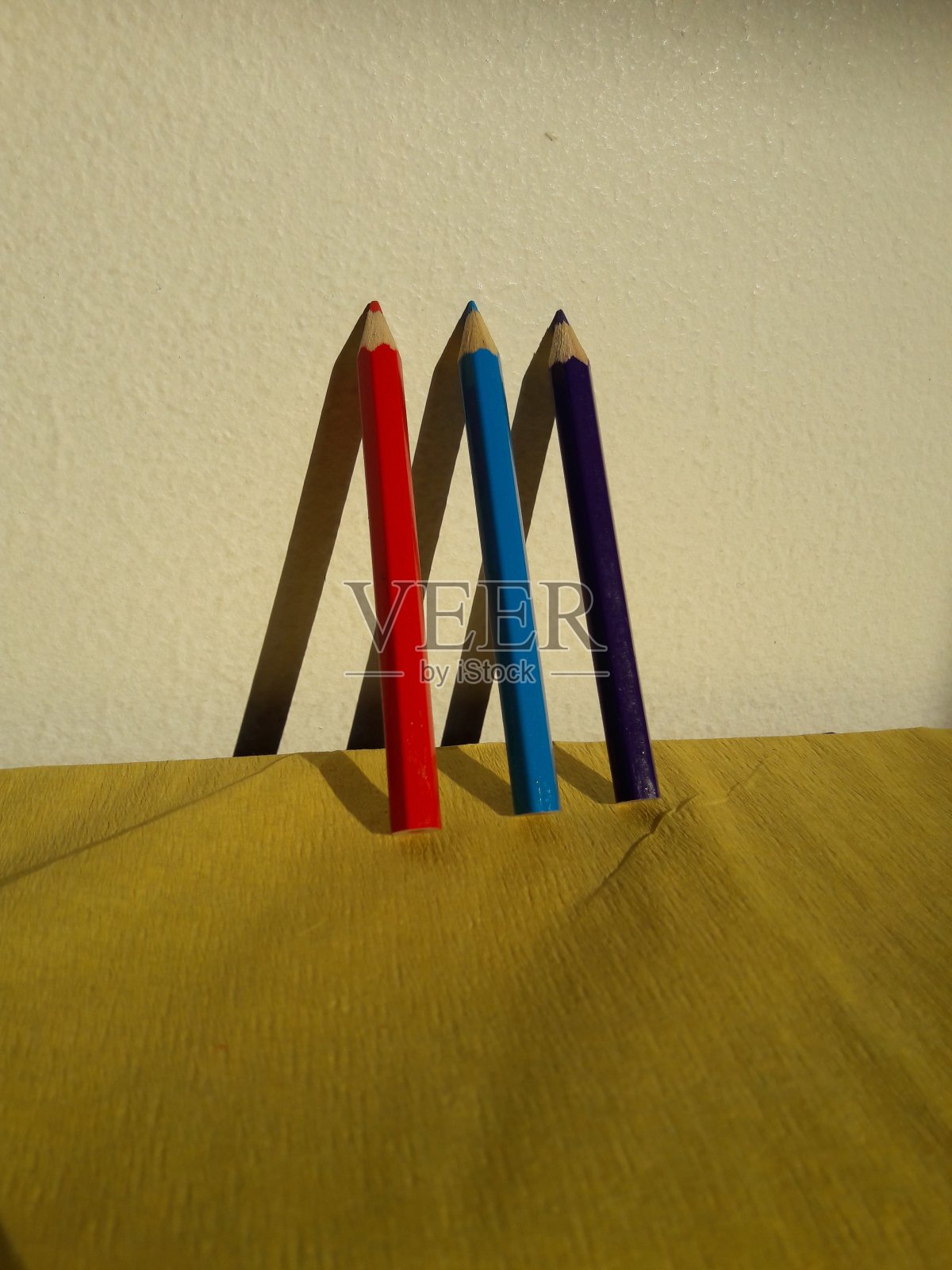 黄色背景上的彩色铅笔和阴影照片摄影图片