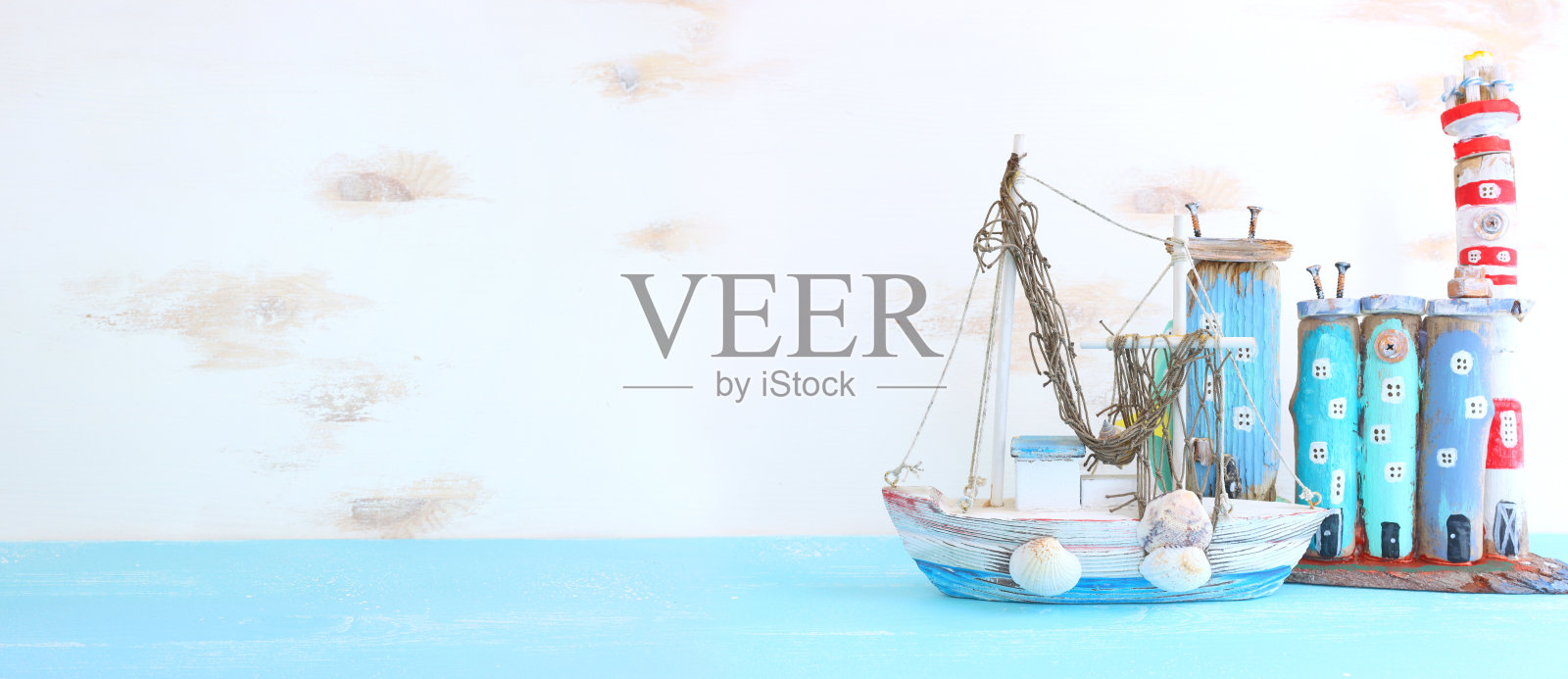 航海概念与海洋生活风格的对象，如船，浮木海滩房屋和贝壳在木制背景照片摄影图片