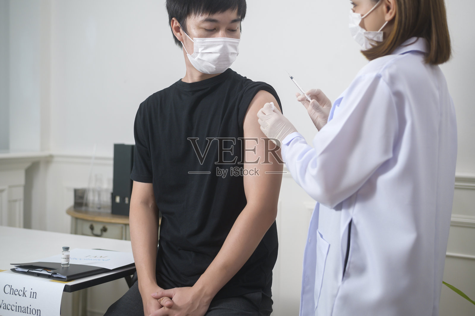 女医生向患者臂注射covid-19疫苗、covid-19疫苗接种和保健理念照片摄影图片