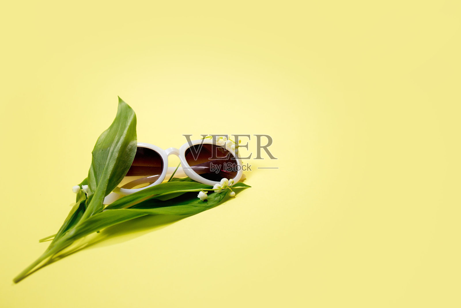 黄色背景的太阳镜。照片摄影图片