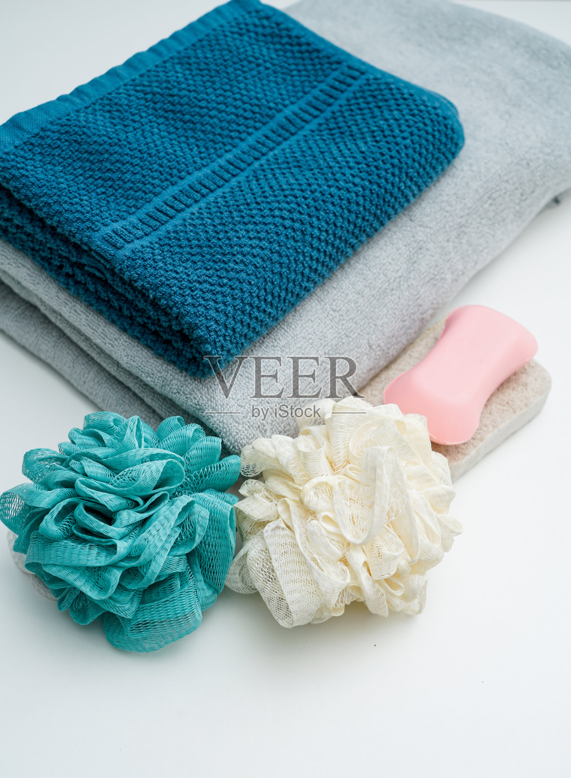 白色的桌子上放着几条毛巾和浴球皂照片摄影图片