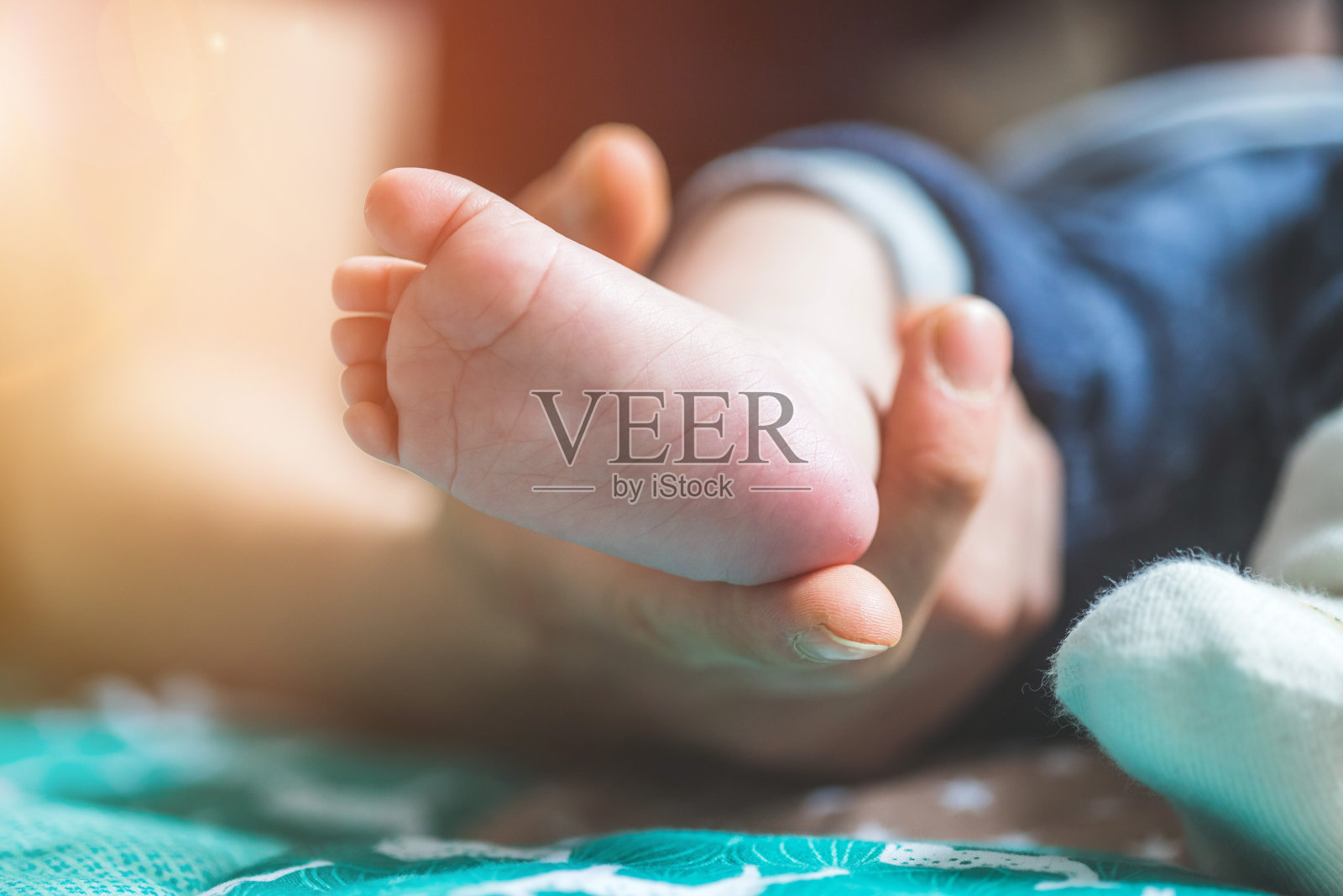 婴儿和新生儿概念:母亲的手抱着新生儿的脚照片摄影图片