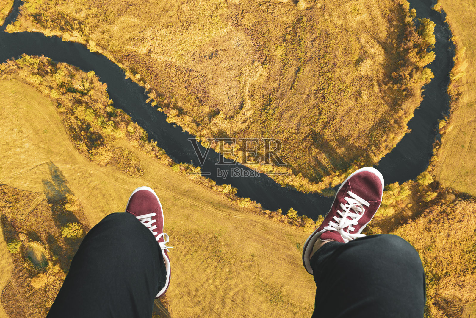 从上到下高瞻远瞩，双腿搭在框架上，观看风景照片摄影图片