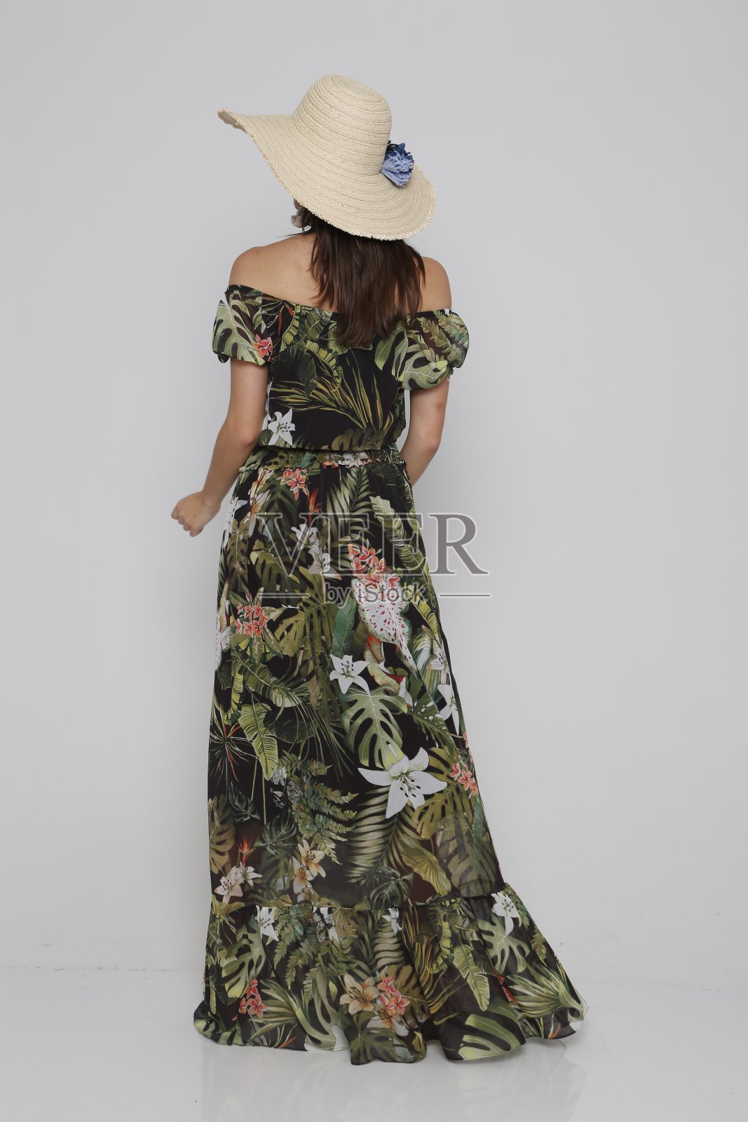 年轻美丽的女人在夏天的服装和帽子前面的白色背景。照片摄影图片