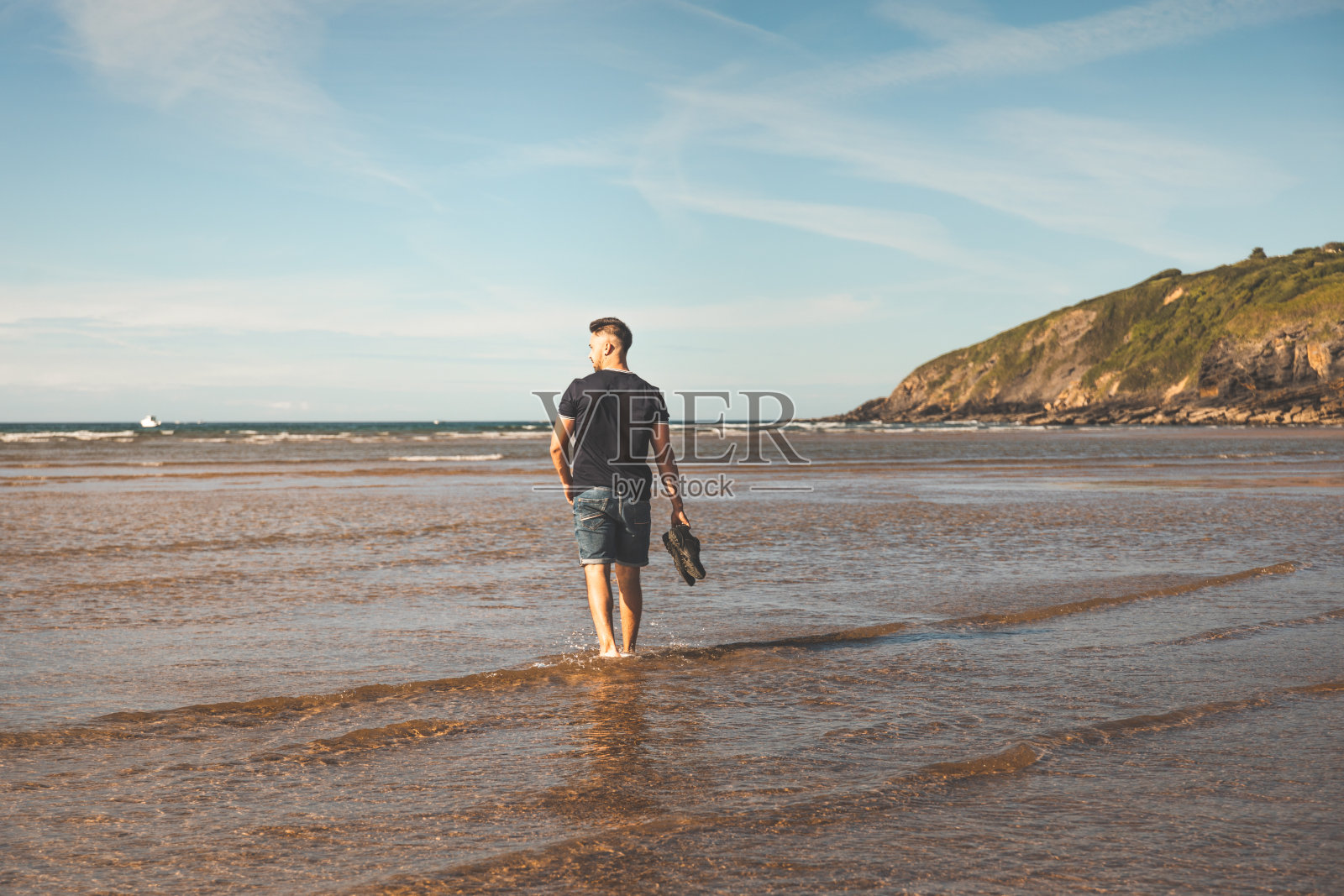 一个年轻的白人在海滩上散步照片摄影图片