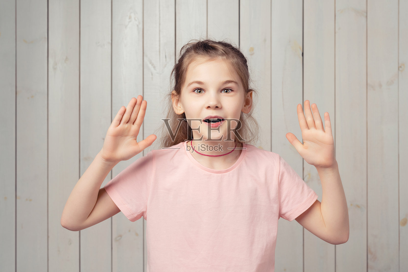 身着粉色t恤的小女孩惊讶地看着镜头说哇，惊愕地摊开双手，掉了东西照片摄影图片