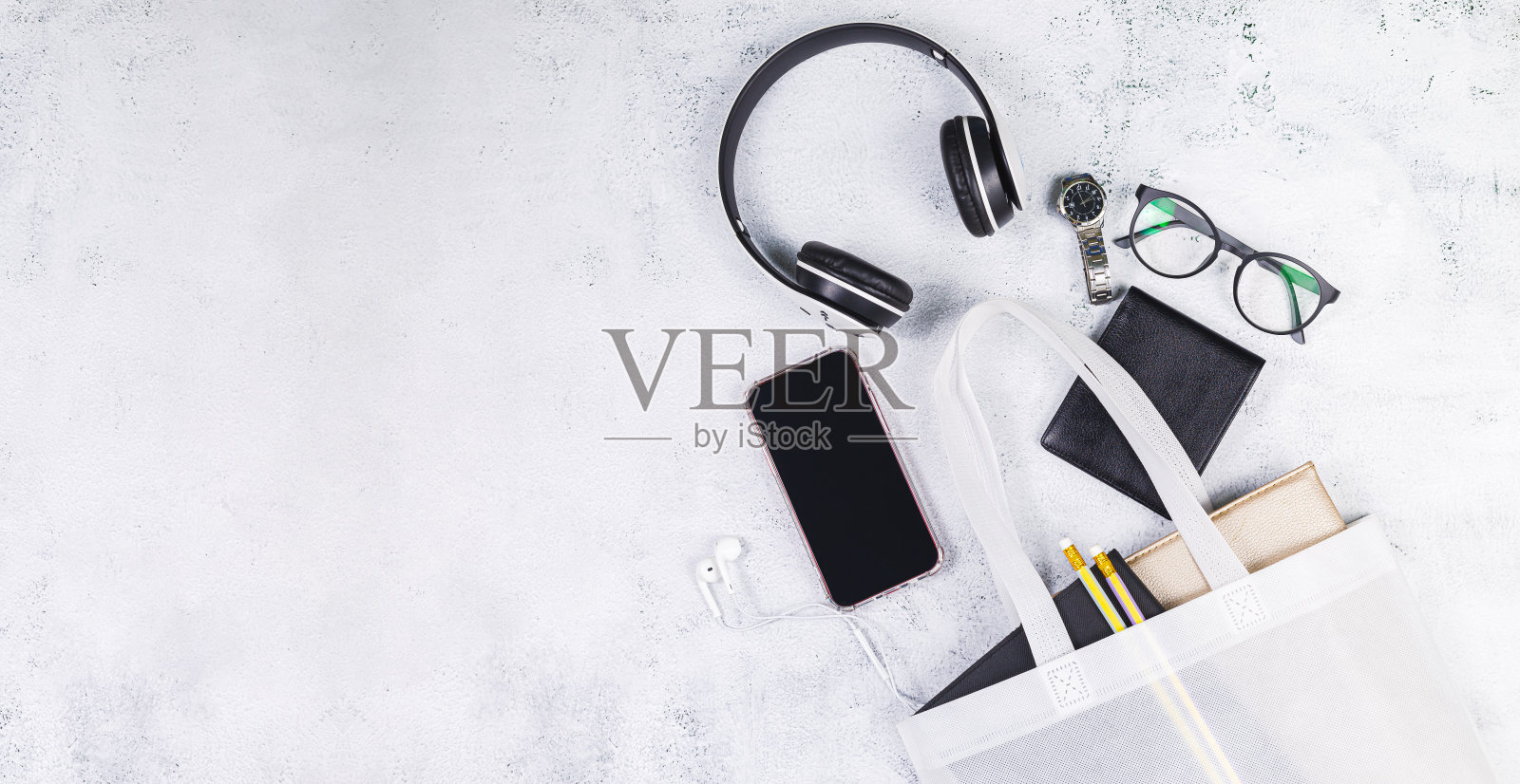 白人妇女的皮包与眼镜书和智能手表，电话，耳机，记事本。照片摄影图片