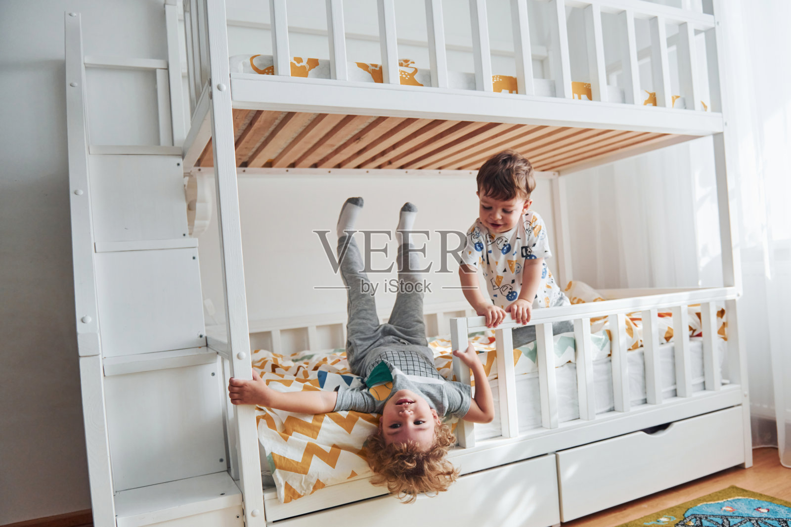 两个小男孩在室内的卧室里休息和玩耍照片摄影图片
