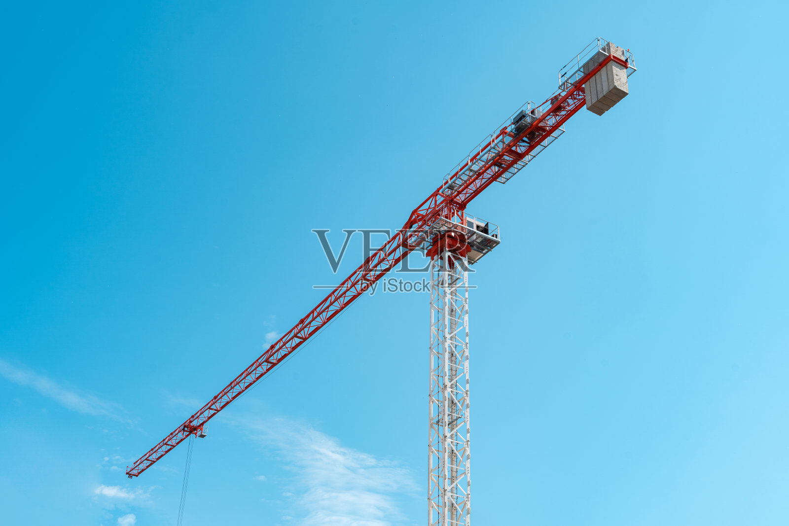 红色和白色的建筑起重机在蓝天的背景。照片摄影图片