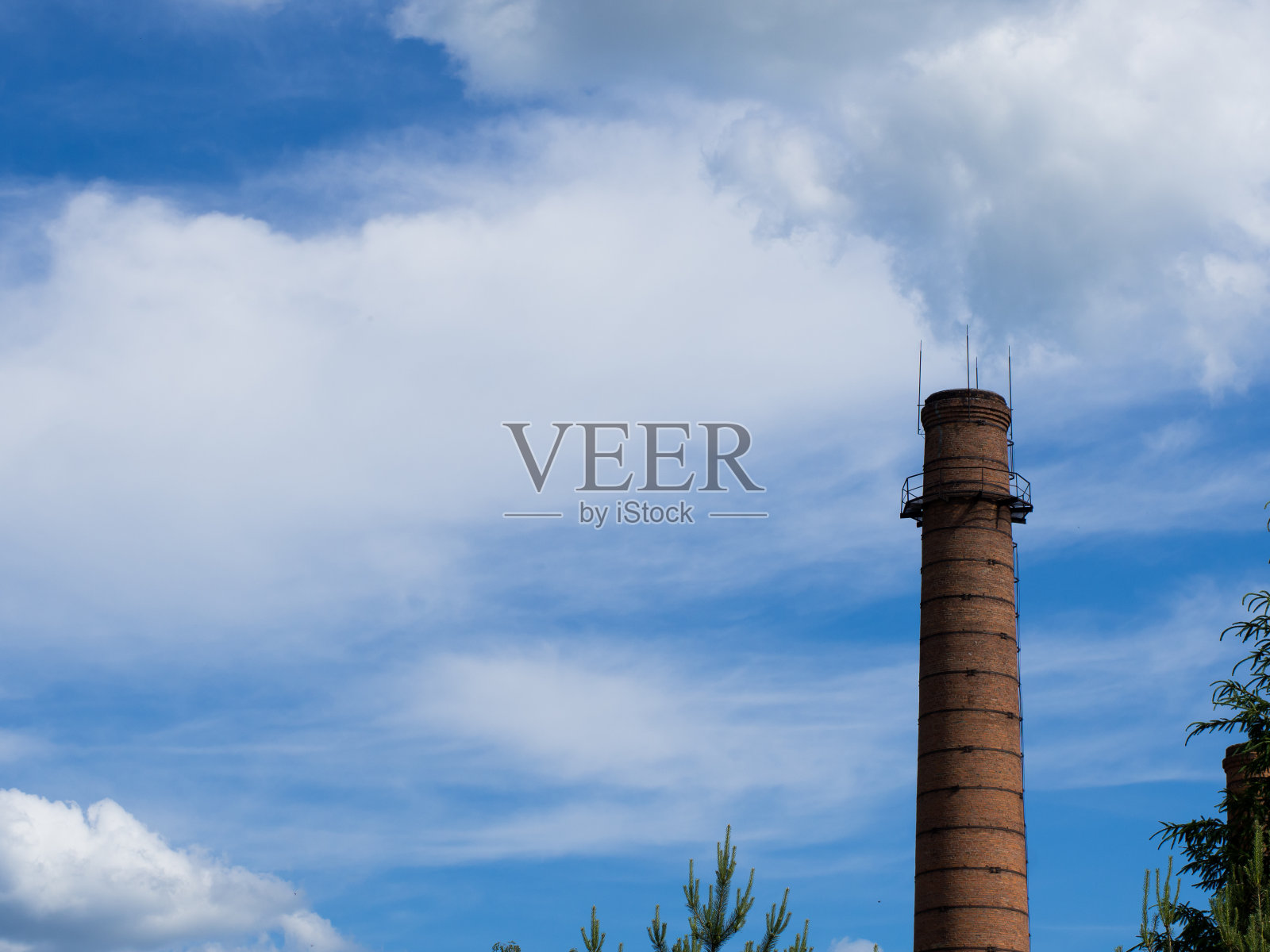 来自工厂的砖管。砖砌烟囱高耸入云。城市里的老工厂。照片摄影图片