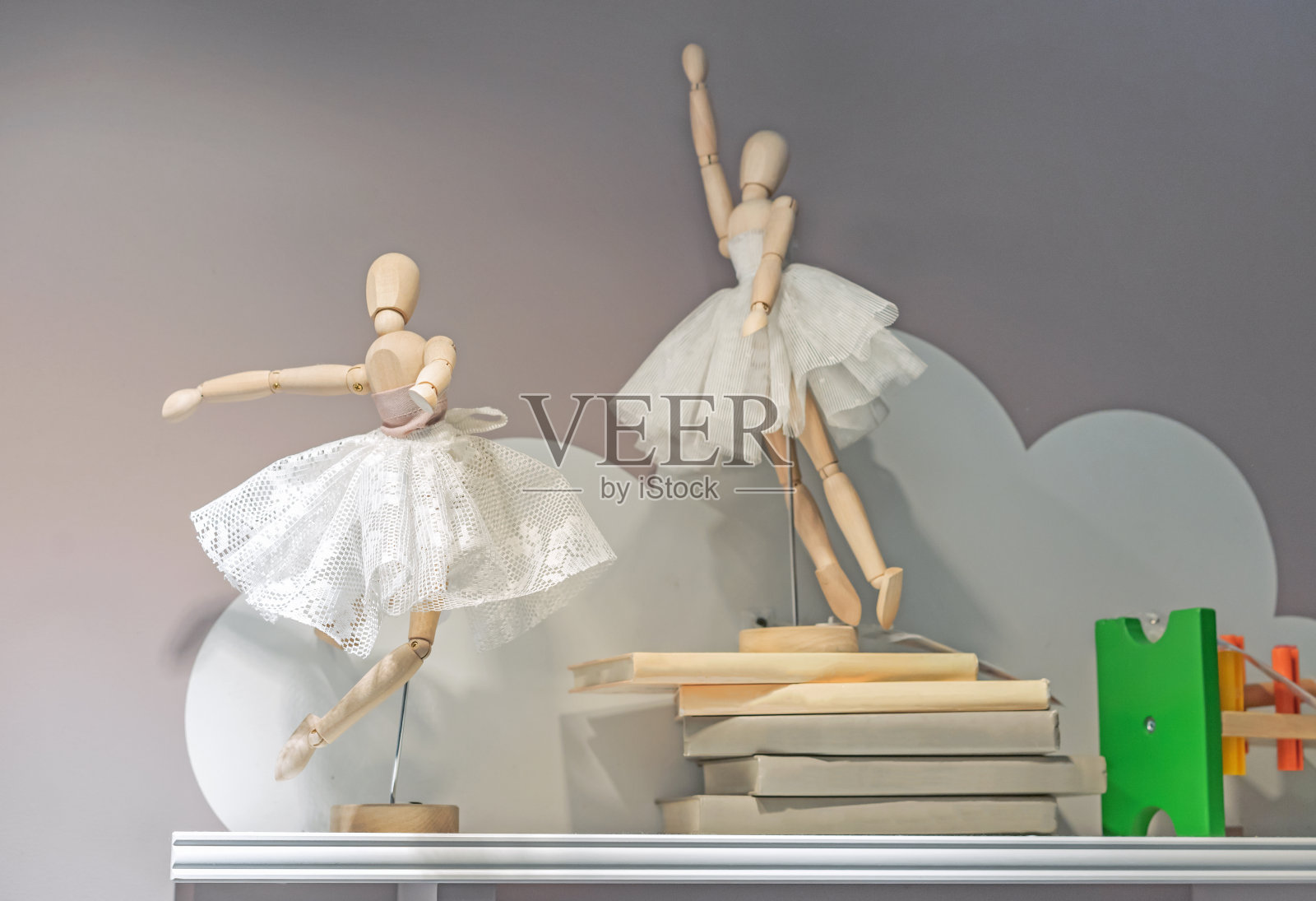 穿着花边裙子的木制芭蕾舞娃娃。完形的芭蕾舞演员玩具。照片摄影图片