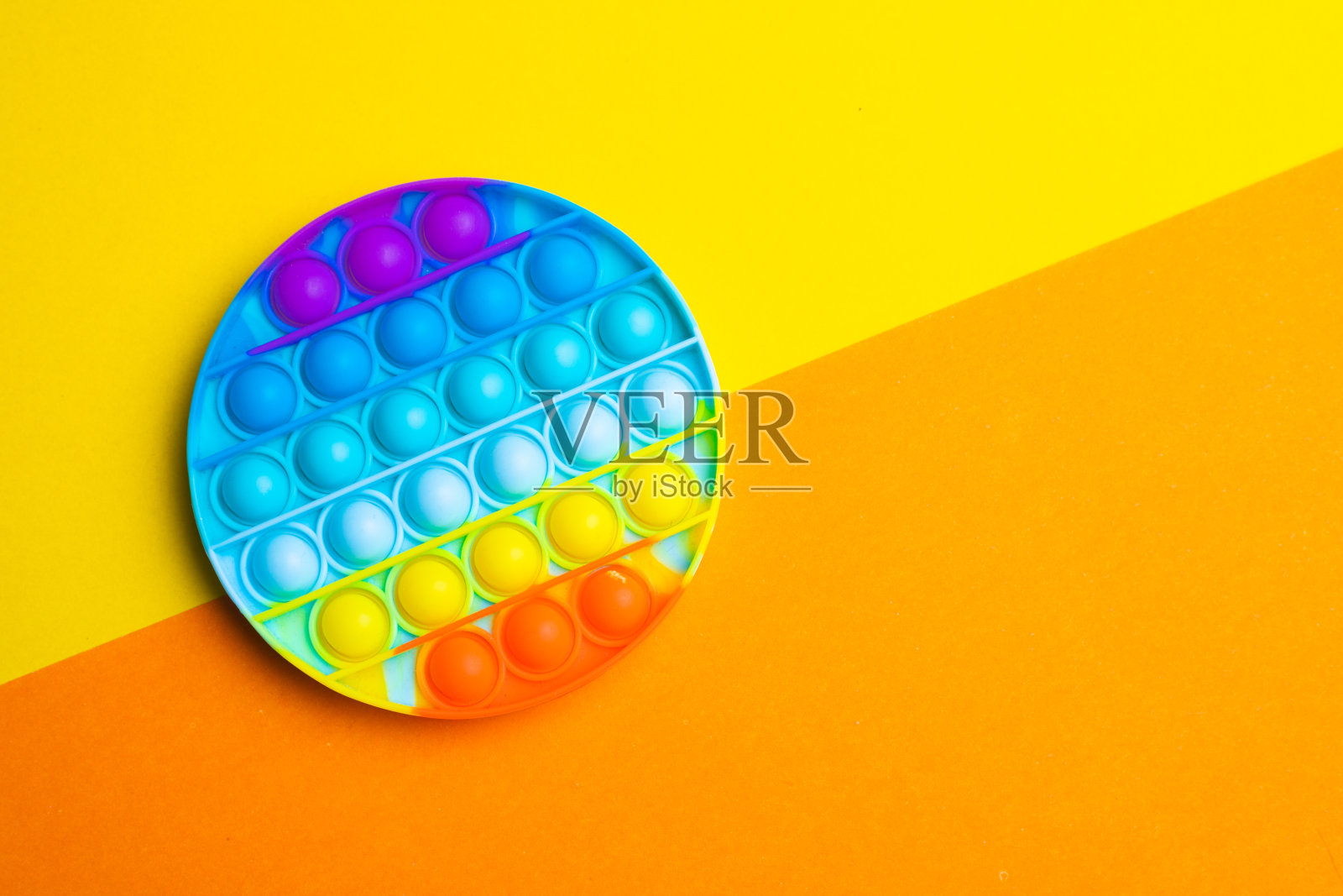 把它放在有色的背景上。现代玩具。儿童玩具。硅胶的游戏。自闭症。本空间照片摄影图片