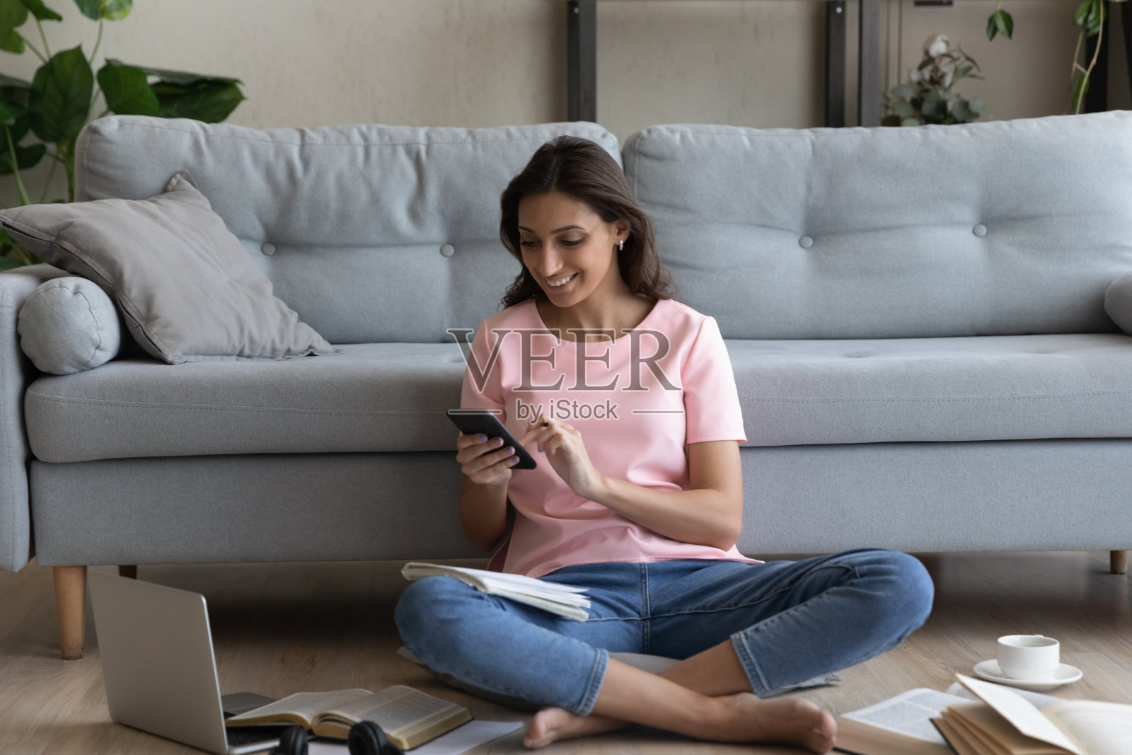 微笑的阿拉伯妇女在家学习时使用智能手机分心照片摄影图片