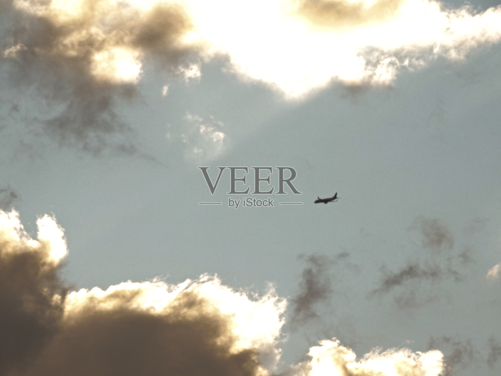 一架飞机在多云的天空中飞行照片摄影图片