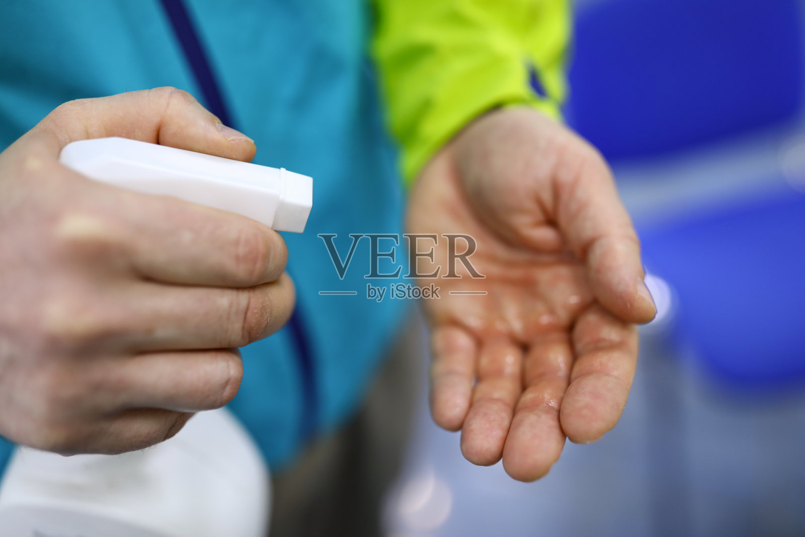 男人手里拿着一瓶白色的消毒液照片摄影图片