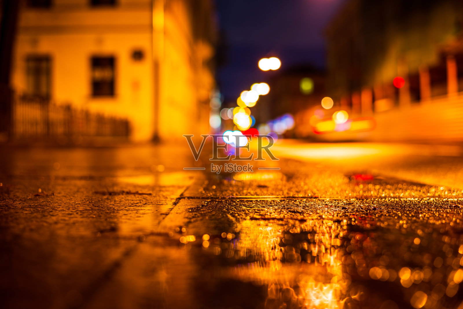 秋雨夜城。空荡荡的大街上挂着灯笼。驶近车辆的前灯。照片摄影图片