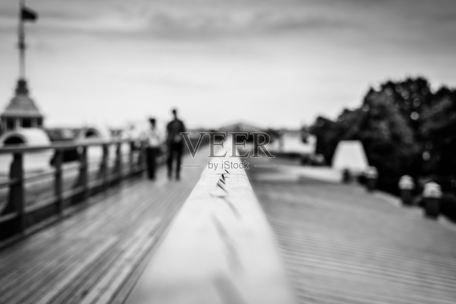 在夏季的城市里，一个步行平台上可以看到城市的全景，一对步行的人。照片摄影图片