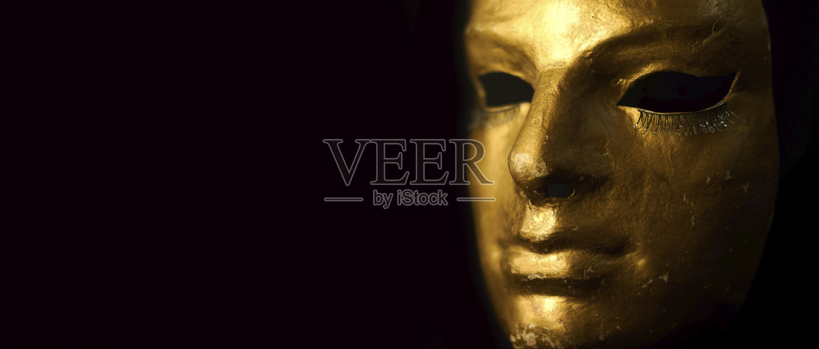 狂欢节金色面具与睫毛在黑色的背景。照片摄影图片