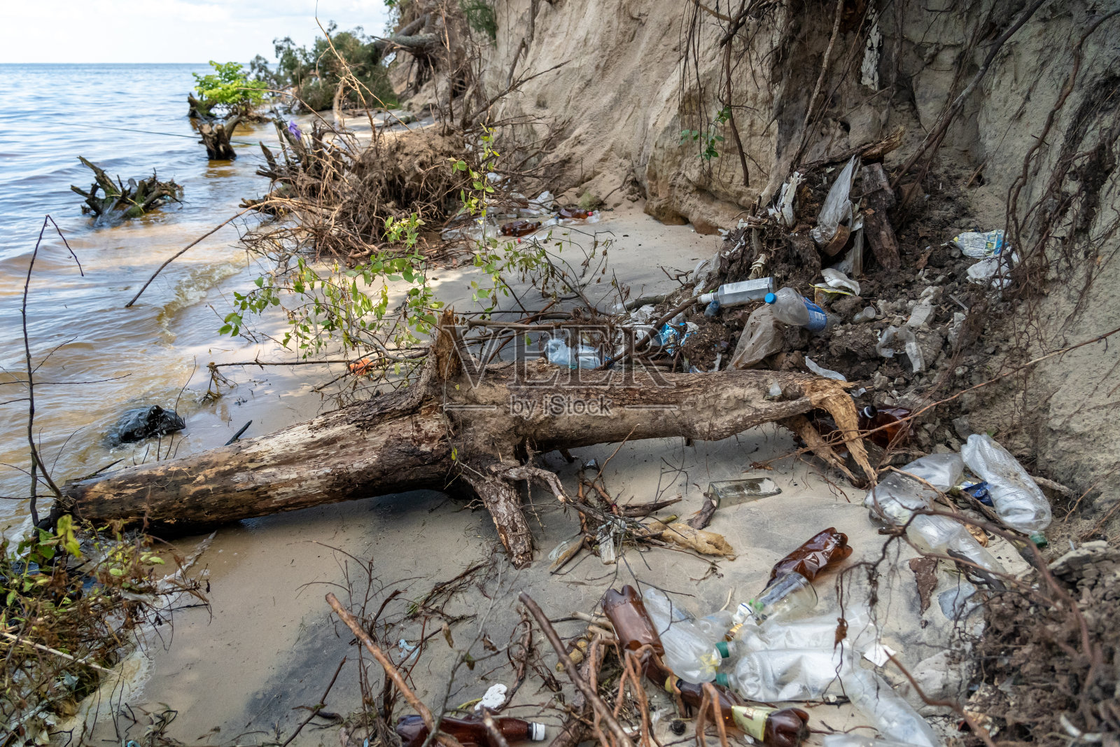 人类活动引起的环境问题。旅游垃圾。乌克兰基辅海污染。池塘岸边的塑料垃圾。坏人在第聂伯河度假后留下的垃圾照片摄影图片