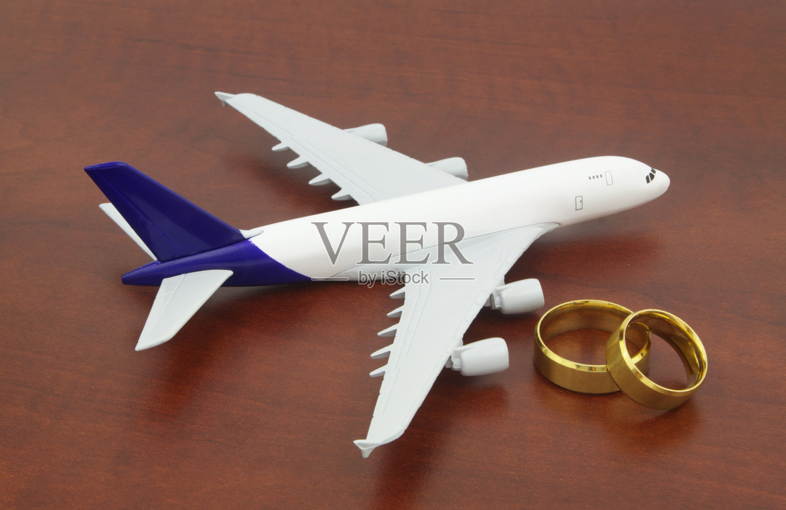 飞机和两个婚礼戒指结束了。照片摄影图片