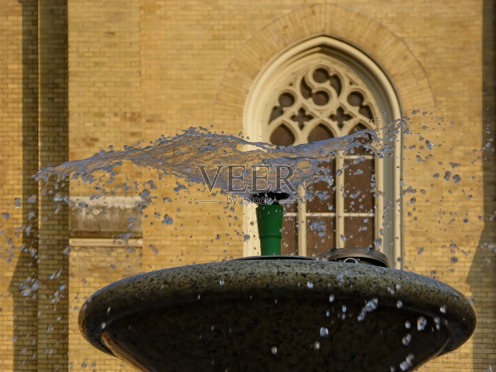 喷射喷泉在窗户前升起和旋转照片摄影图片