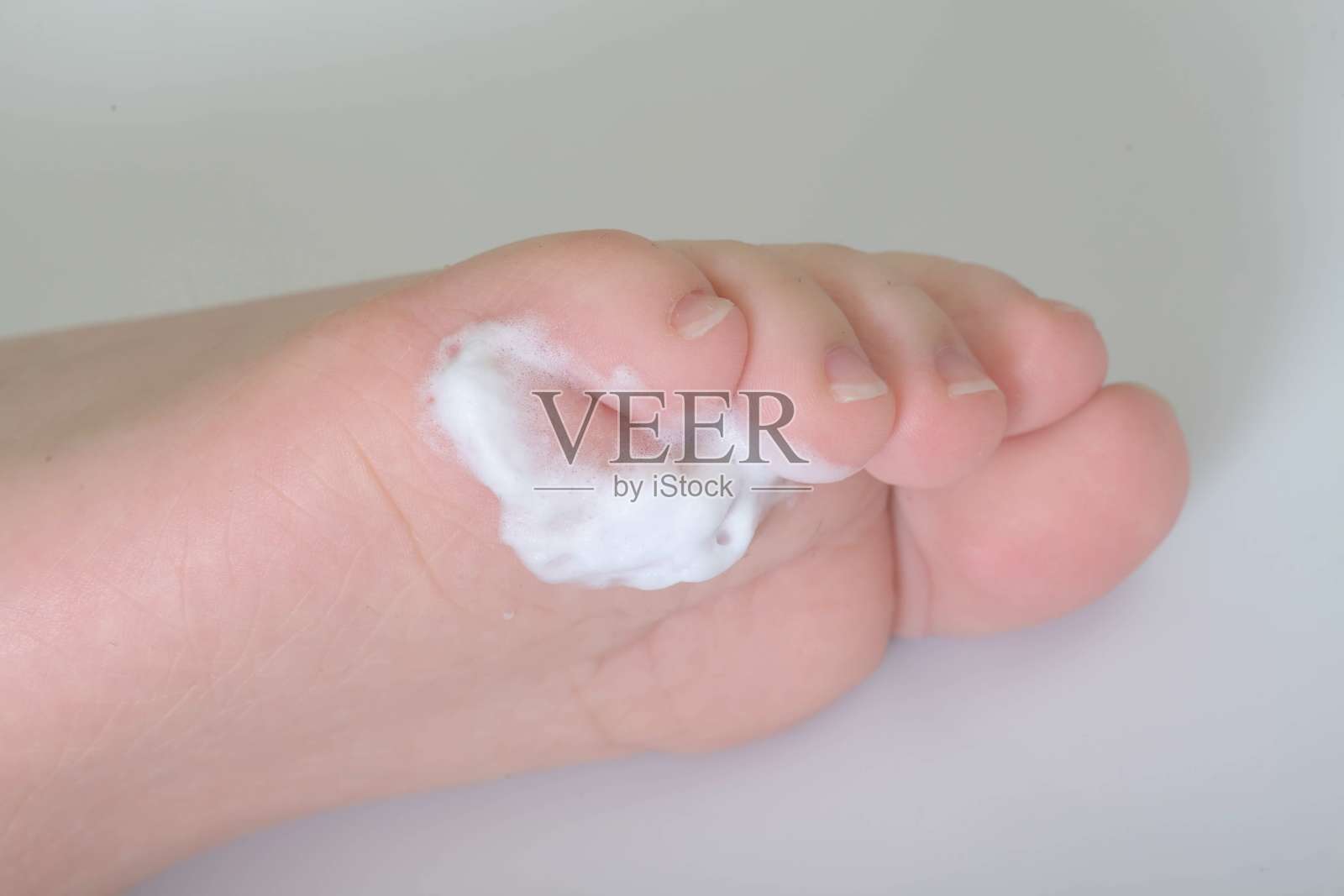 孩子的脚底伤口用泡沫治疗照片摄影图片