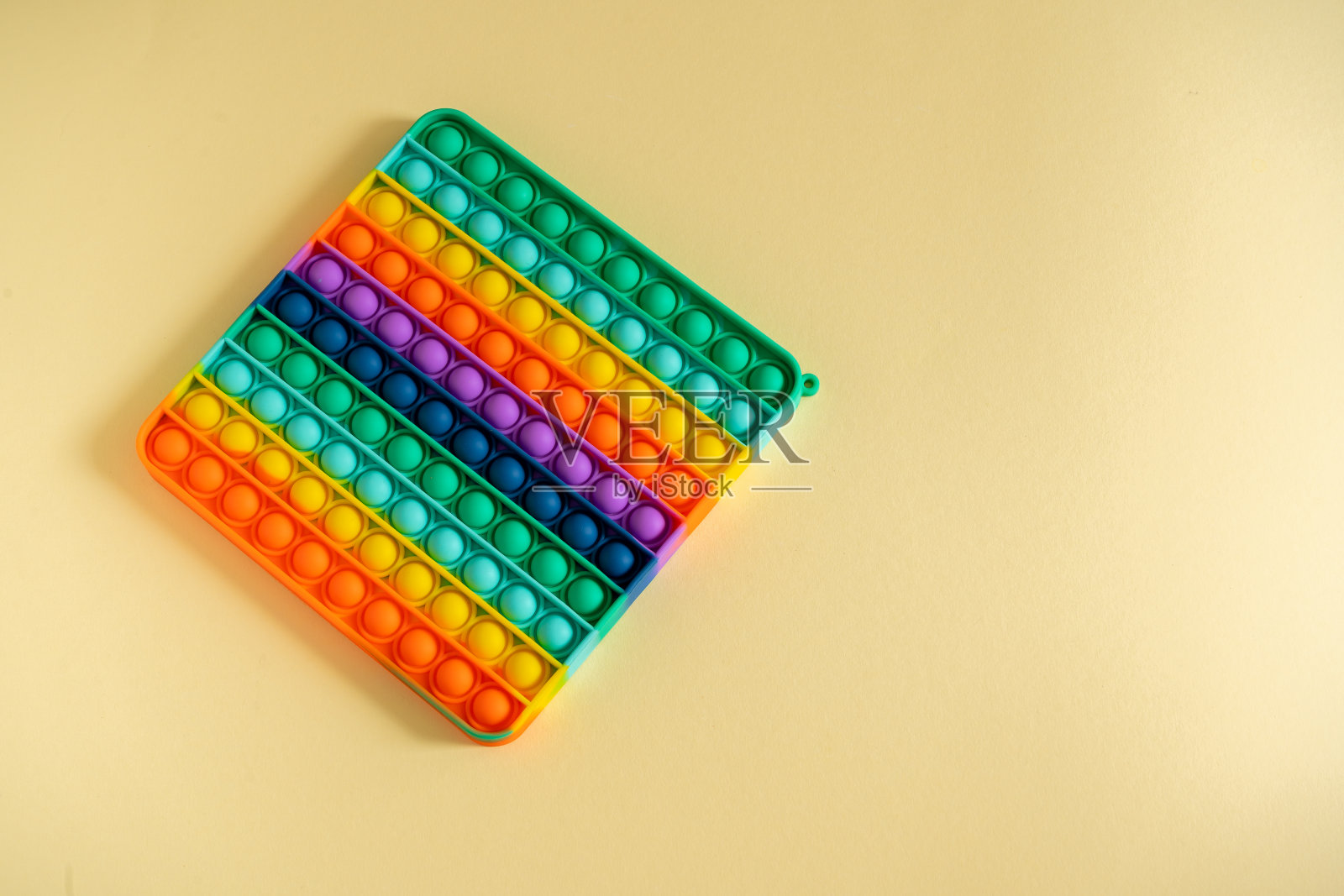 大波普孤立在黄色背景上。亮硅胶条纹玩具大Pop It特写。孩子们用手指按压泡泡，俯视图。新的抗压力玩具为儿童和成人照片摄影图片