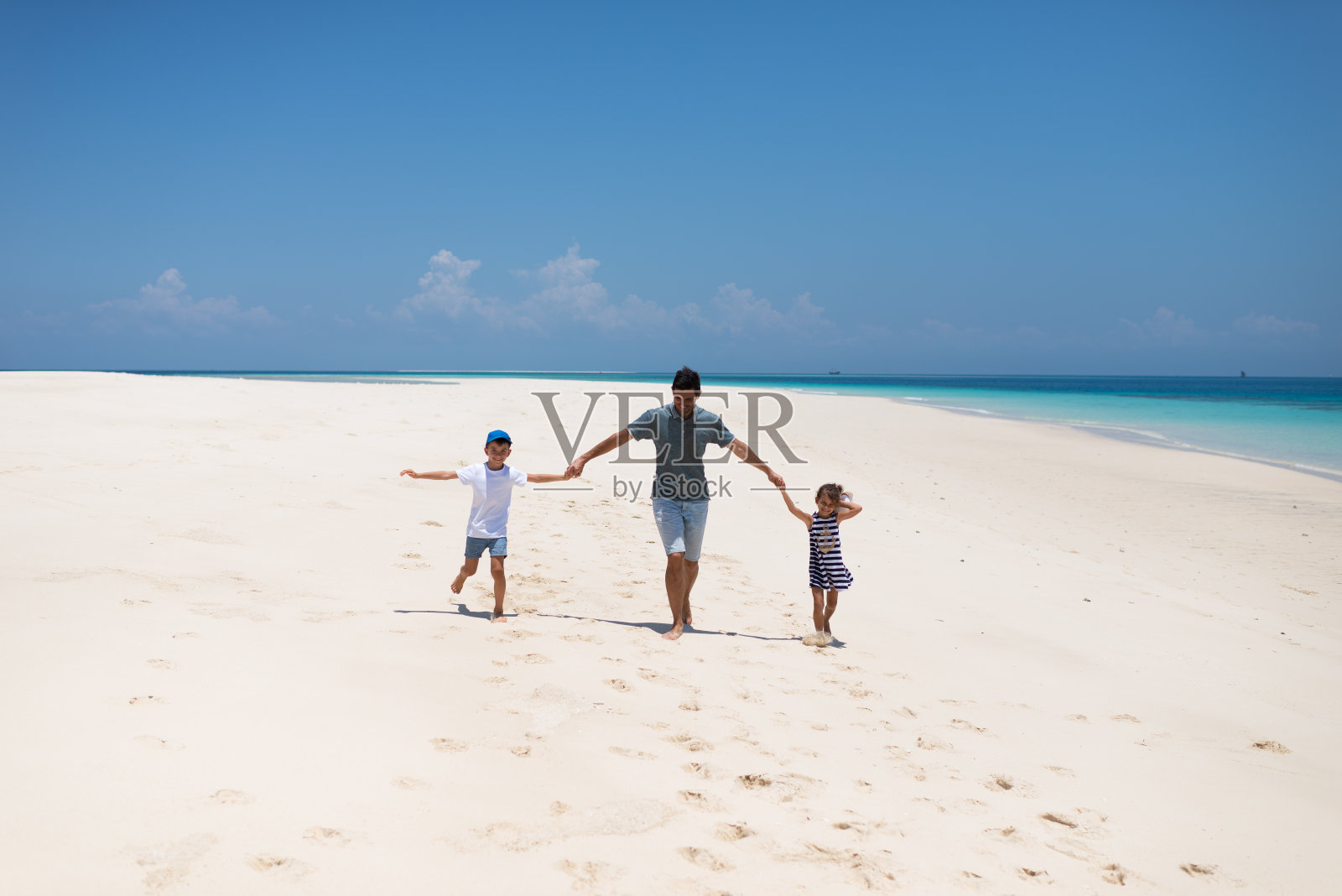 快乐的父亲和孩子们在海滩上跑来跑去照片摄影图片