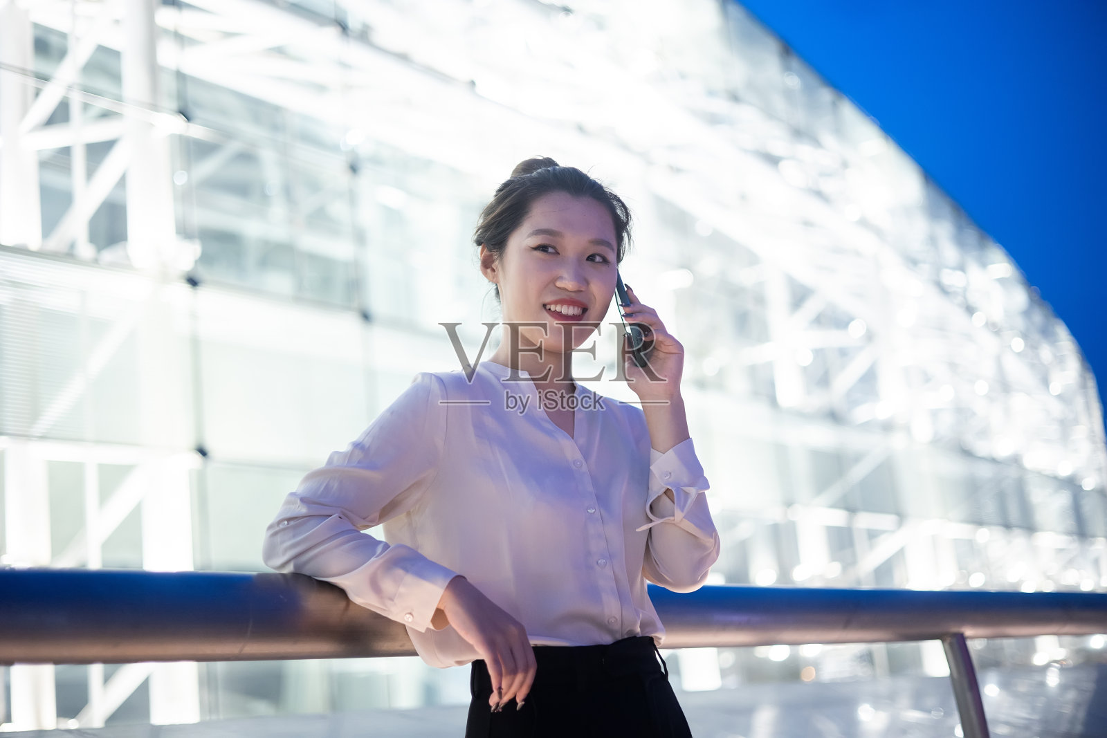 年轻的女商人在晚上打电话照片摄影图片