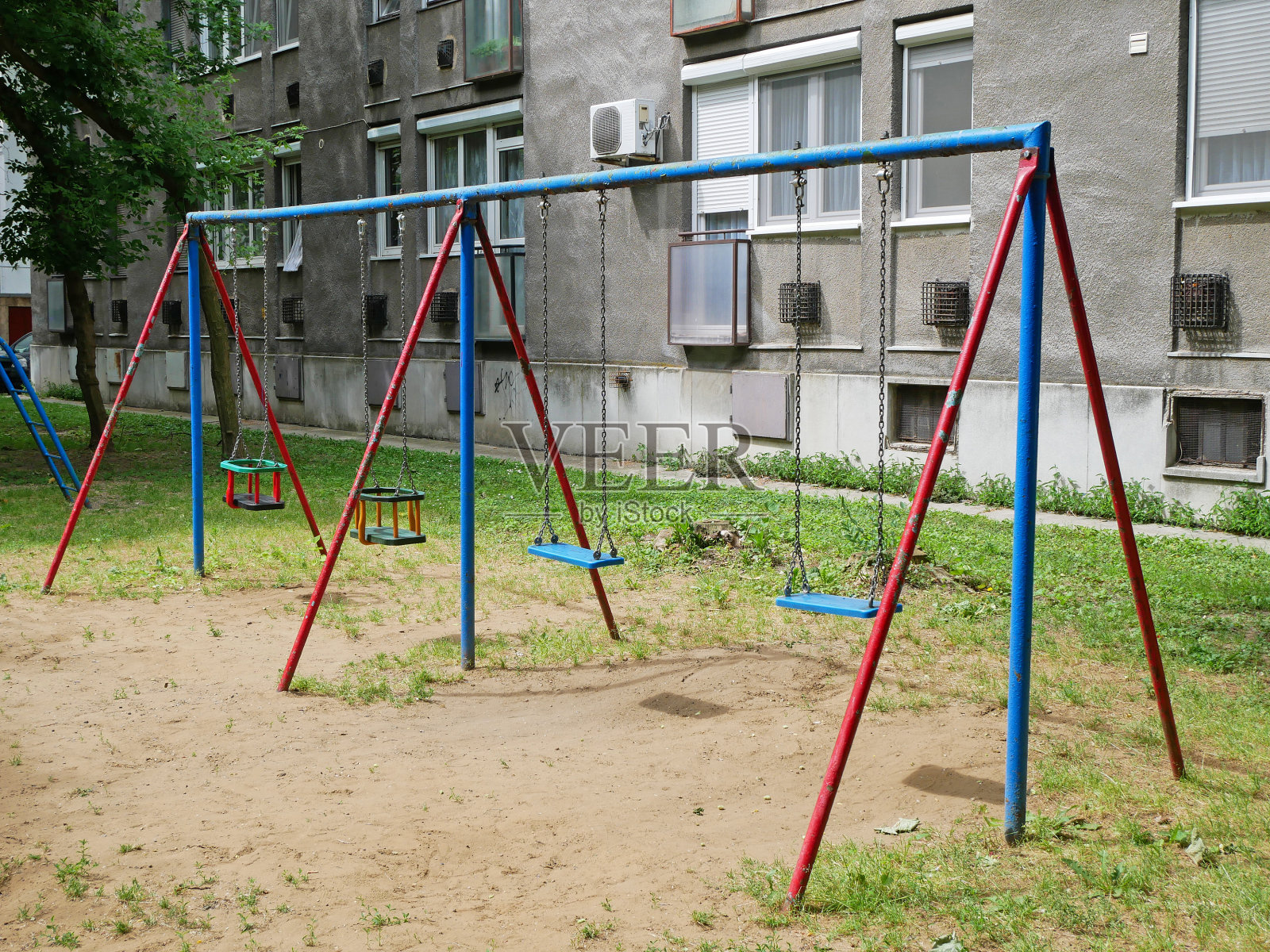 在公寓楼旁边的操场上荡秋千照片摄影图片