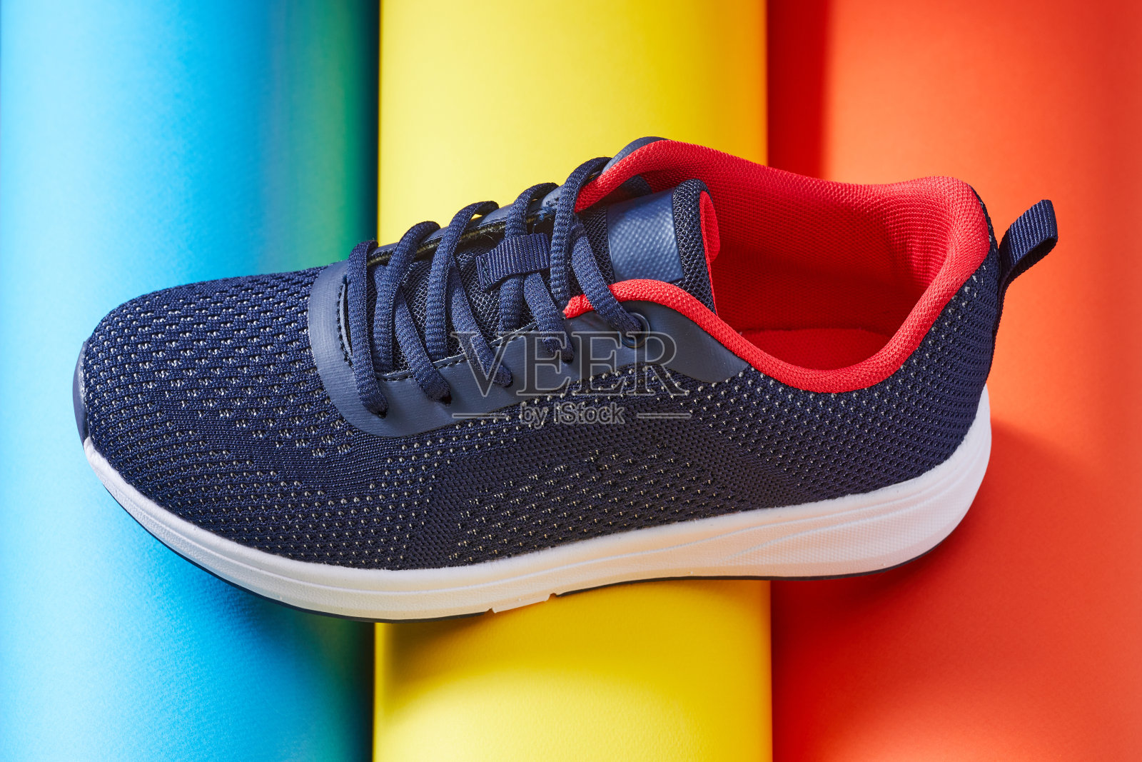 女性时尚时尚的运动鞋与彩色管跑。一款运动鞋或多色鞋。黄色，红色，蓝色背景。照片摄影图片