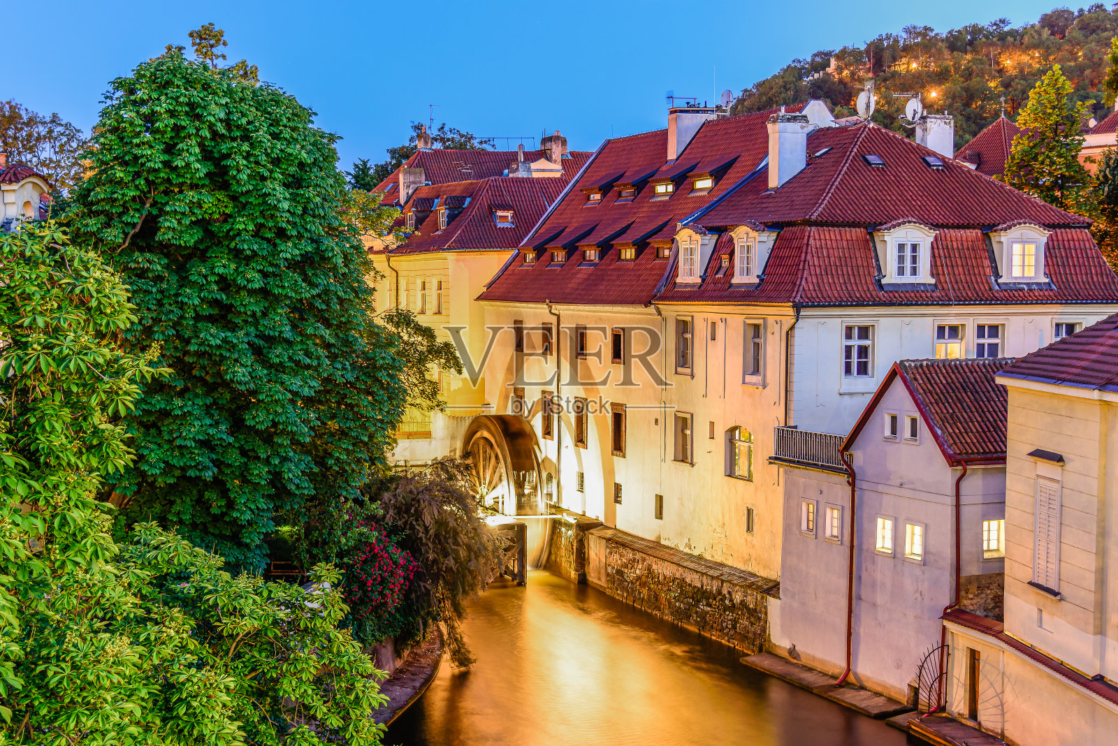 在历史名城布拉格，一条发光的切尔托夫卡运河和水车。照片摄影图片