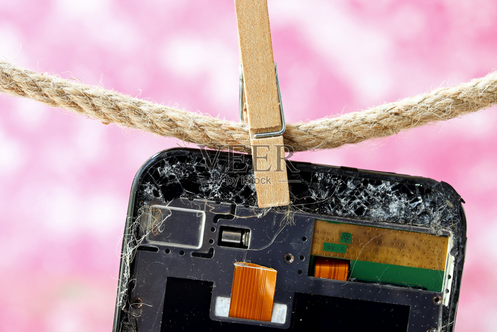 挂在晒衣绳上的破手机照片摄影图片