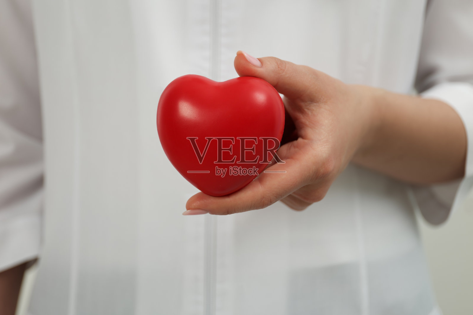 医生抱着红心，特写。心脏病学的概念照片摄影图片