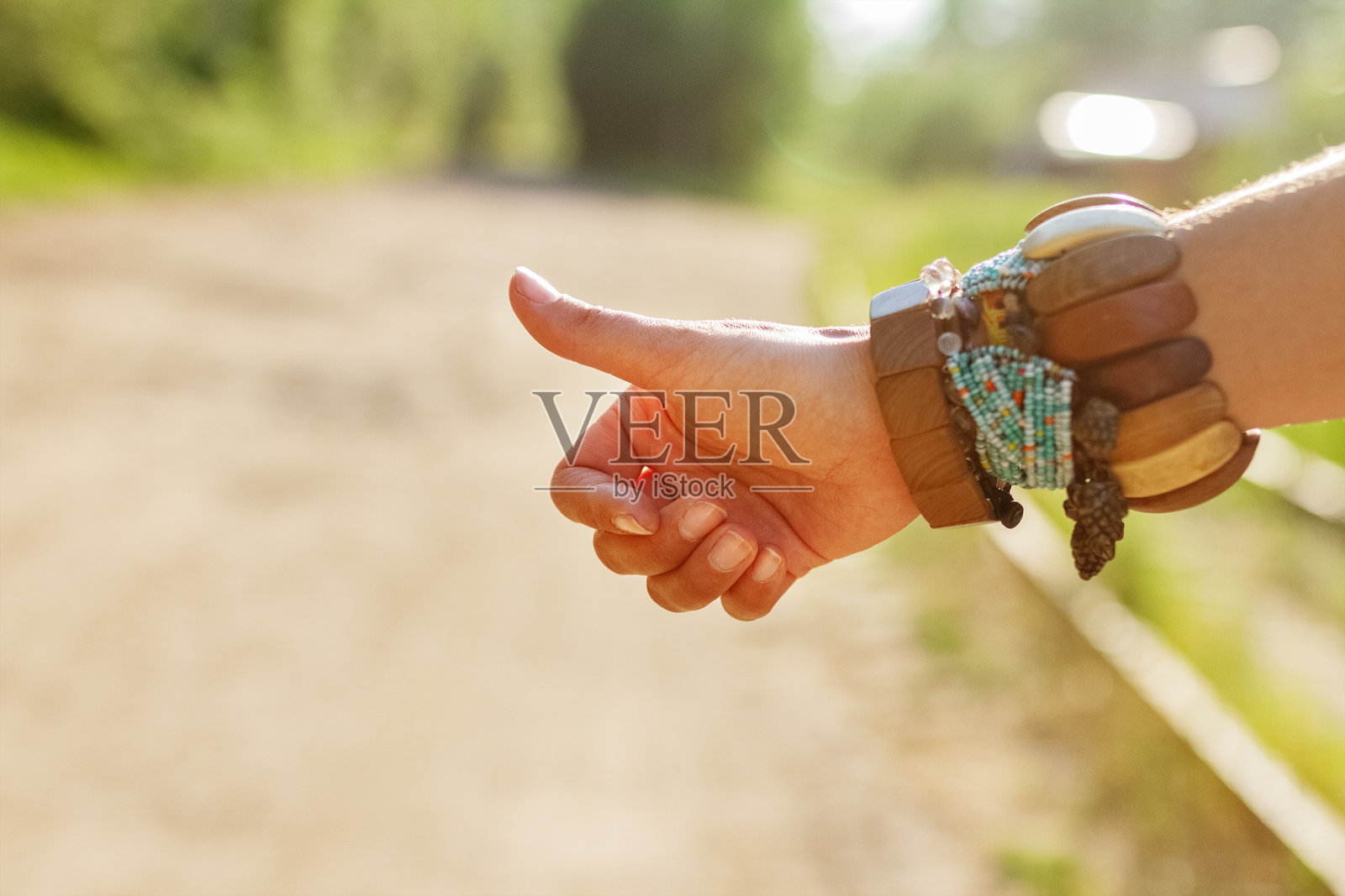 夏天的一天，女性手拿民族手镯在路上投票照片摄影图片