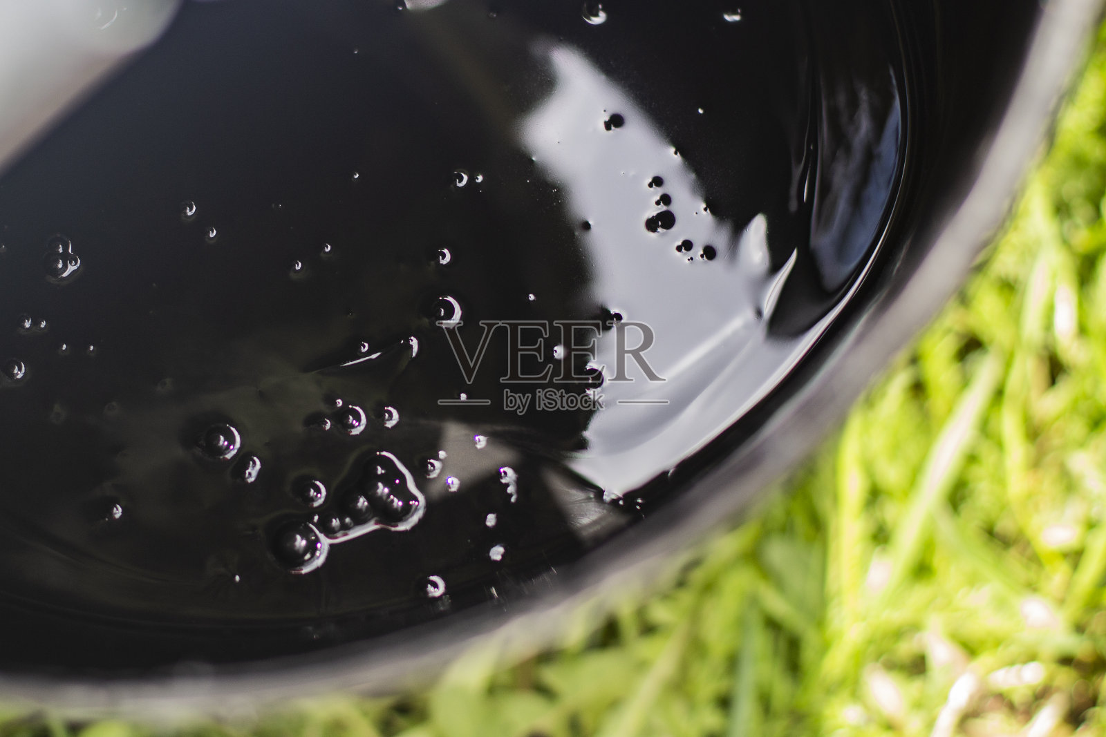 刷子上的黑色颜料和桶里的黑色颜料。照片摄影图片