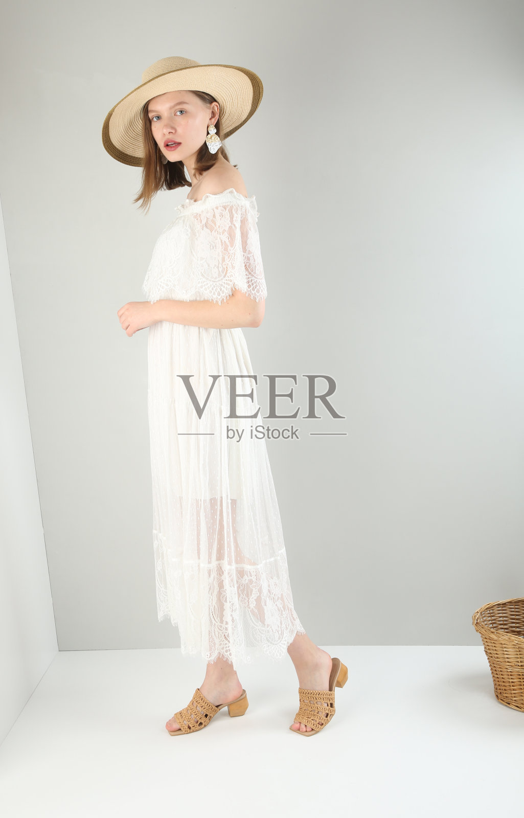 年轻美丽的女人穿着白色的裙子，白色的背景。照片摄影图片