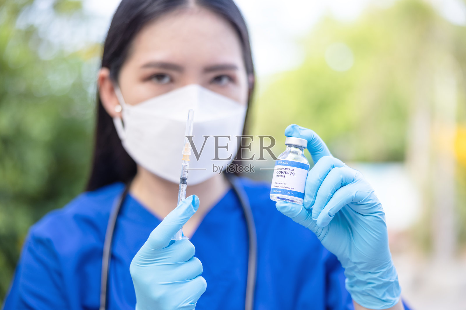 医生手持蓝色丁腈手套，手持流感、麻疹和注射器、冠状病毒疫苗。Covid-19病毒,照片摄影图片