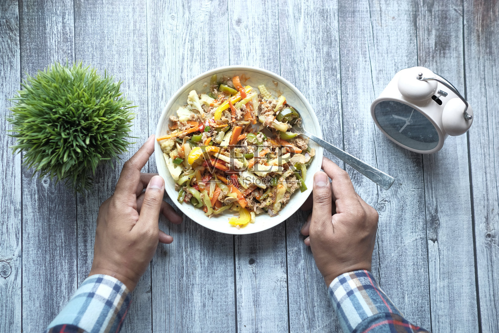 年轻人穿着休闲装吃新鲜沙拉，崇尚健康饮食理念照片摄影图片